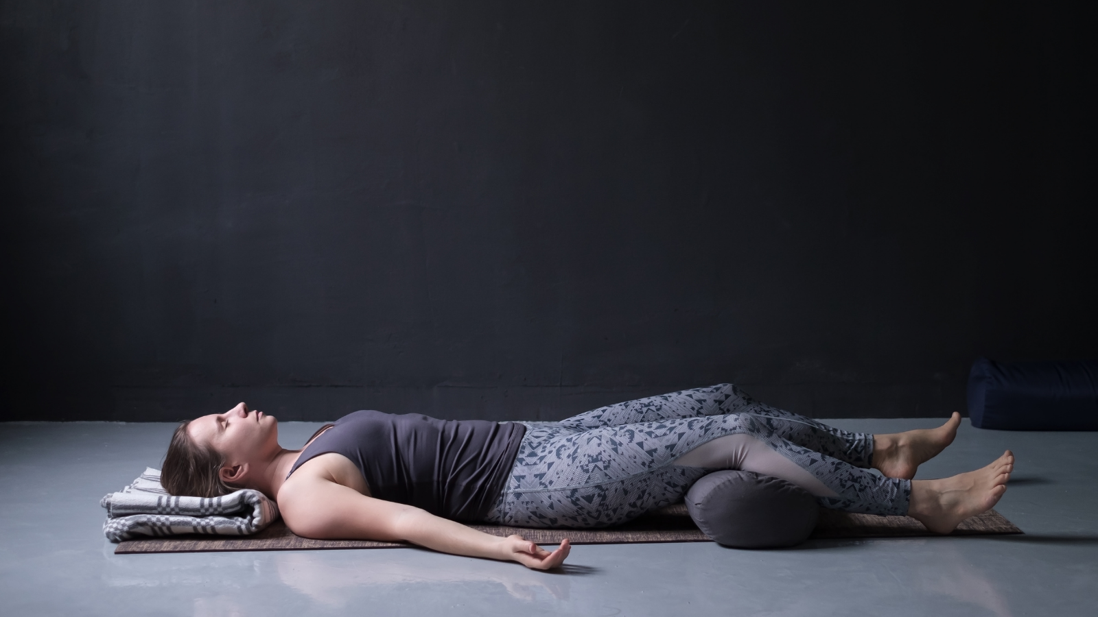 Young woman practicing yoga's Savasana or Corpse Pose.